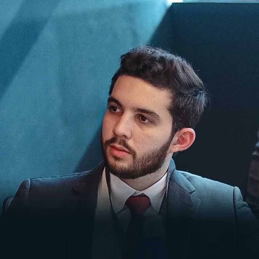 Bernardo Cunha, advogado, de terno cinza e gravata vermelha, olhando para o lado